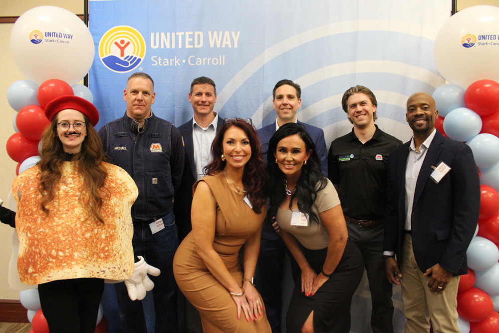 A group of people poses together at an awards banquet.