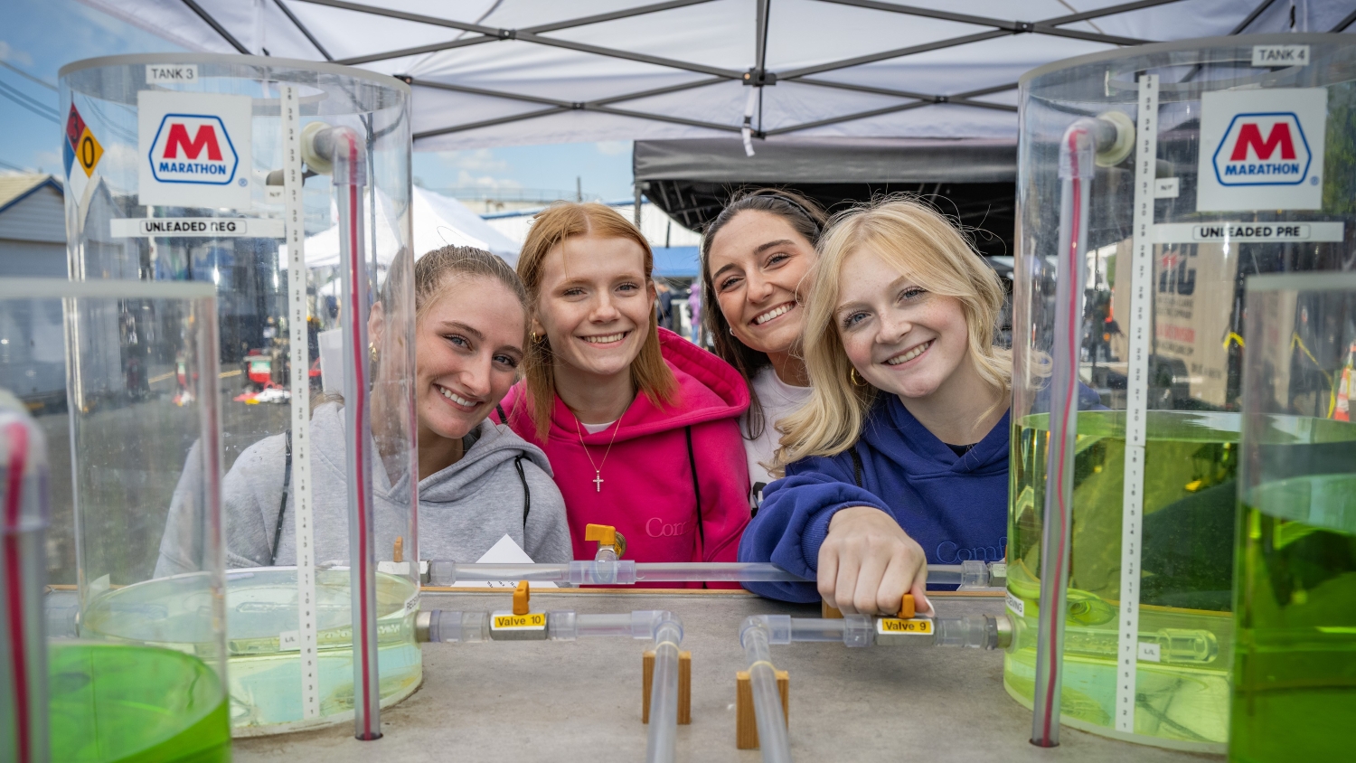  Four girls pose for a photo at an outdoor event at Marathon Petroleum.
