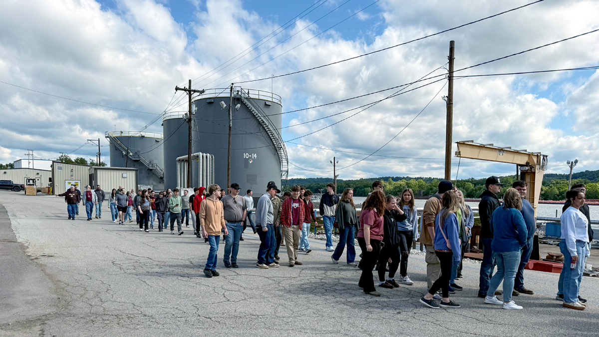 Students walk along a road at a marine facility.