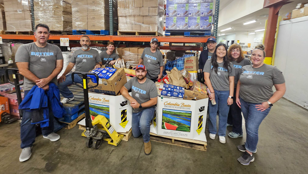 People standing in a warehouse with boxes of food. People standing in a warehouse with boxes of food.