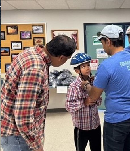 A boy tries on a bike helmet. A boy tries on a bike helmet.