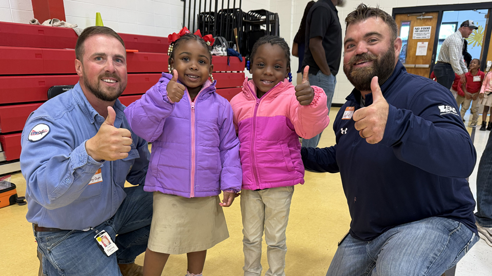 Two adults stand with two children wearing new coats.