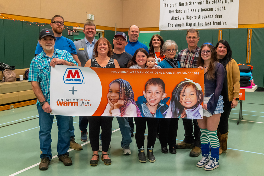 A large group of people pose together indoors.