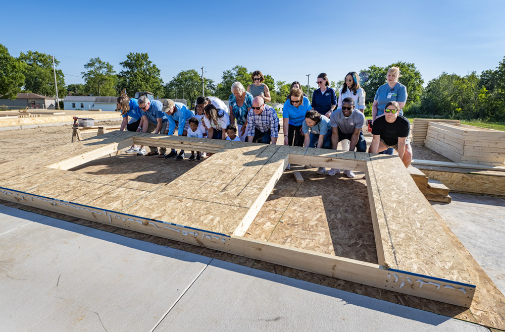 : A large group poses for a photo before lifting a wall into place at a Habitat for Humanity home build in Findlay, Ohio.  
