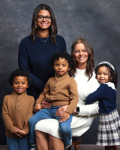 A mother poses for a family portrait with her four children.