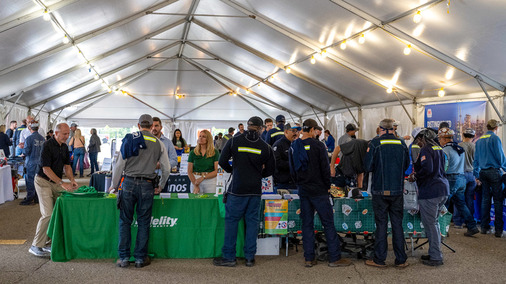 A group of people in a tent looking at items on display.