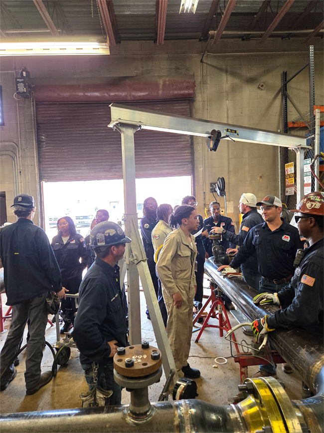 People in a garage maintenance area talking.