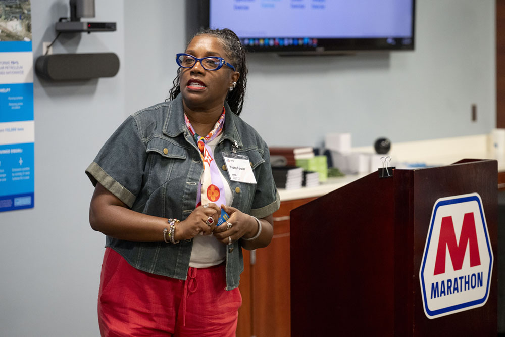 A woman stands behind a podium during a presentation.