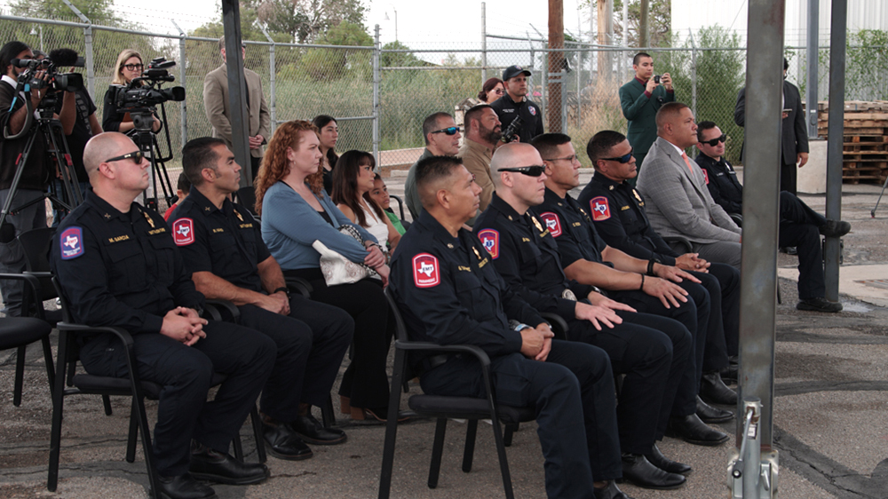 Several people sit in chairs arranged int two rows.