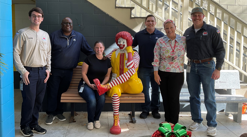 Galveston Bay refinery employees stand together at Ronald McDonald House of Galveston during a check presentation.