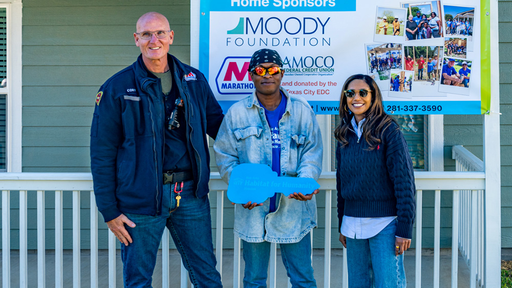 Three people posing together at an event.