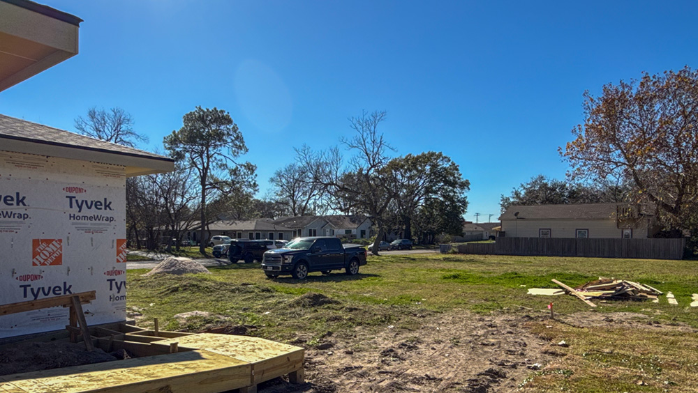 A yard with building materials and early construction activity.