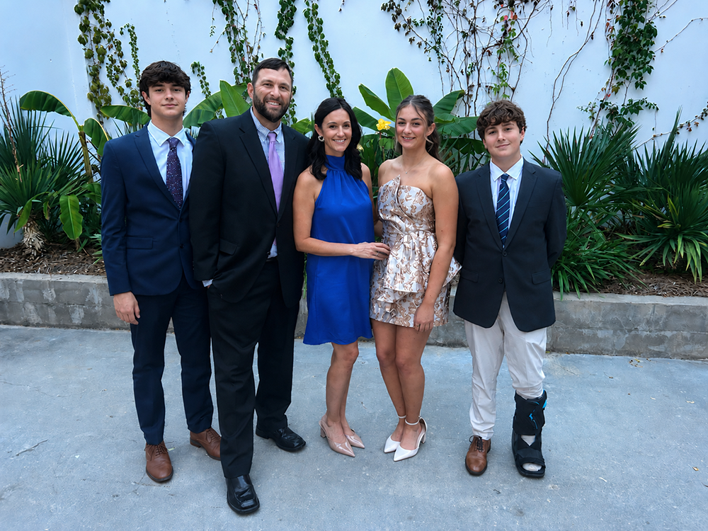 A family of five poses together for a photo.