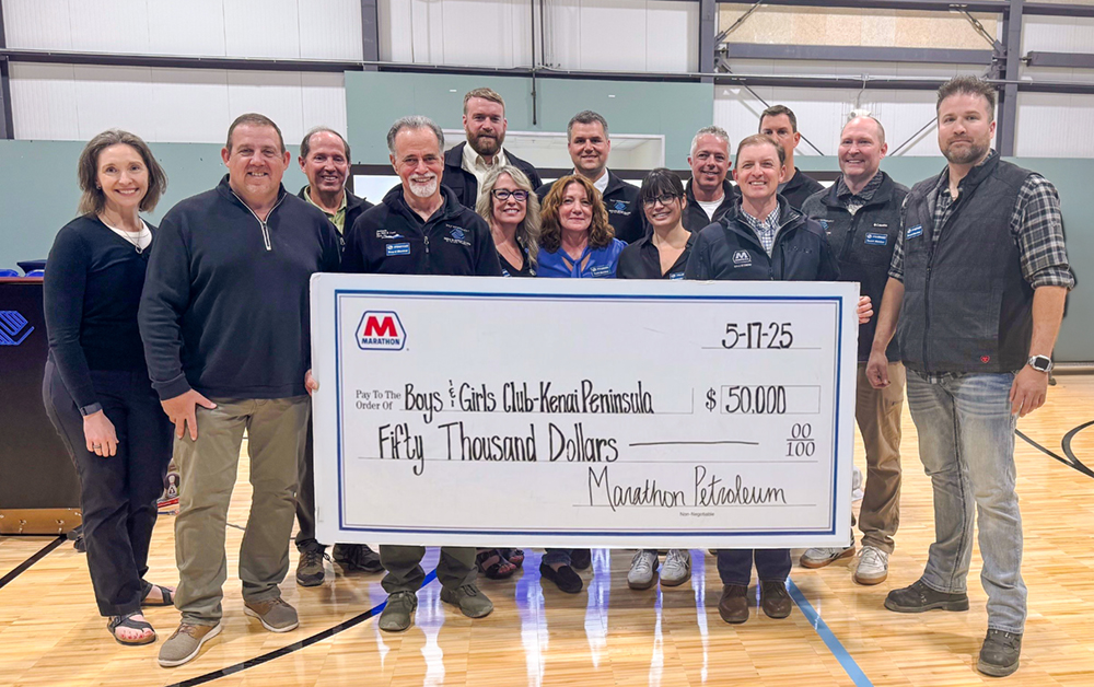  group of people stand in a gym holding a large check for $50,000 to the Boys & Girls Club-Kenai Peninsula