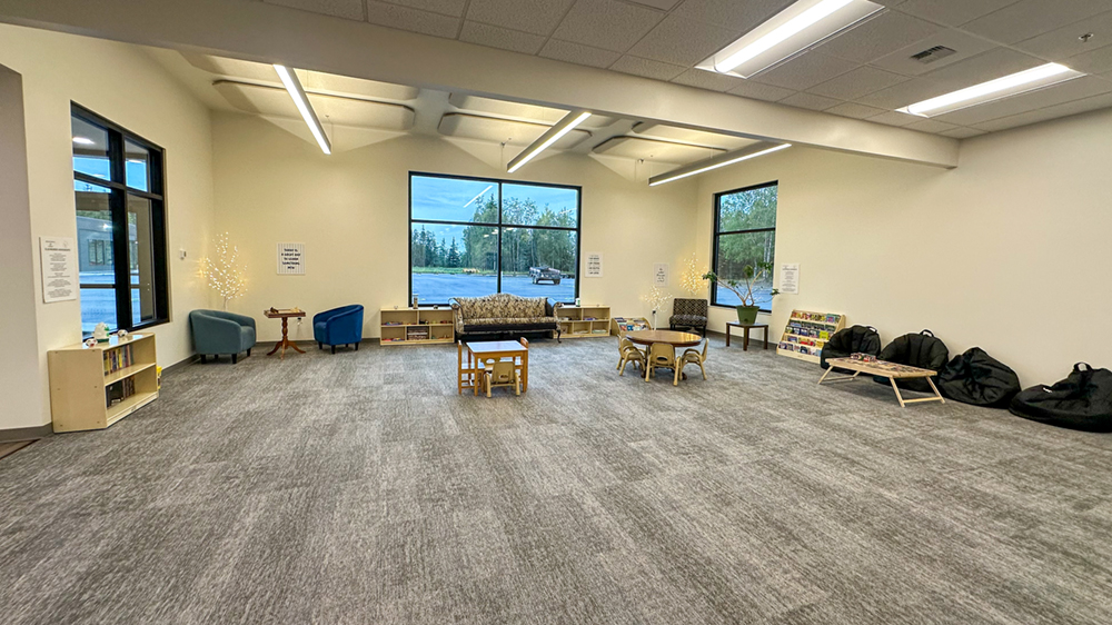 The interior of a new building with tables, chairs and a couch.