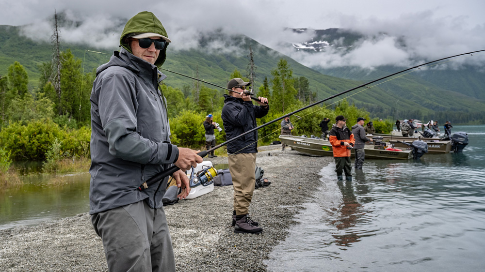 People fishing on the shore of a lake. 