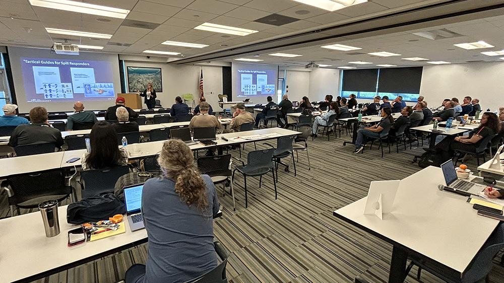 A group of people in a classroom listening to a presentation.
