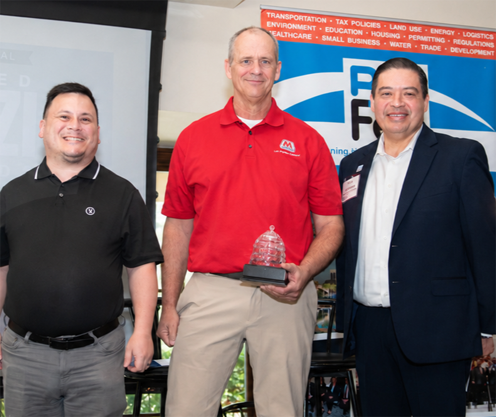  Three people standing together for a photo at an event.