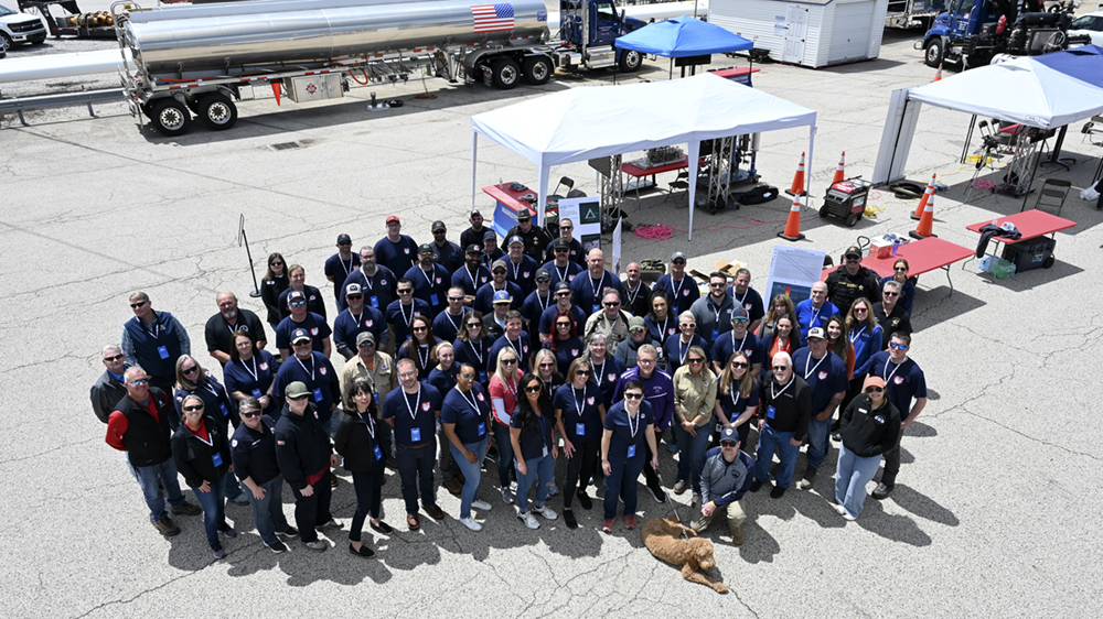 A large group of employees stand together for a group photo at a company event.