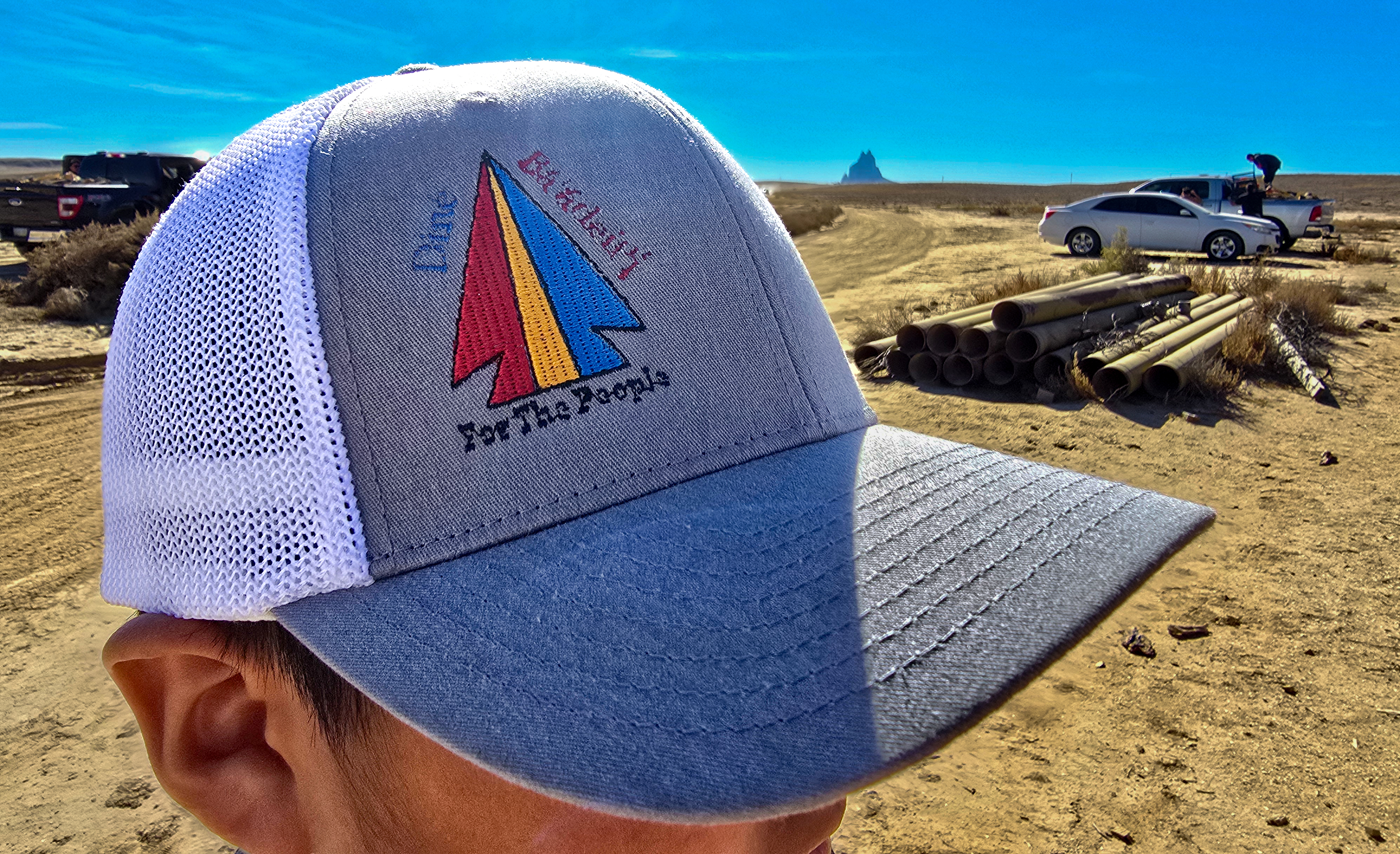 A person wearing a baseball cap with a logo on the front.