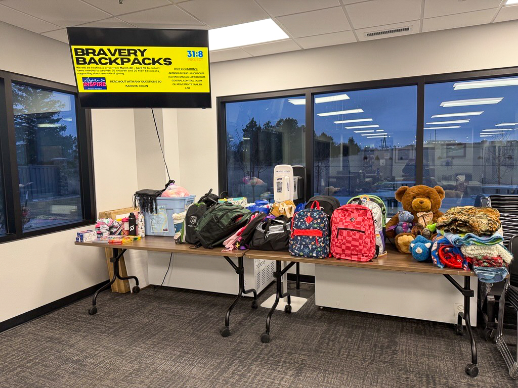 Filled backpacks and donated items on a table.