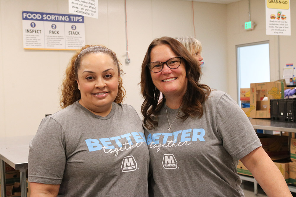 Two smiling volunteers pose together. 