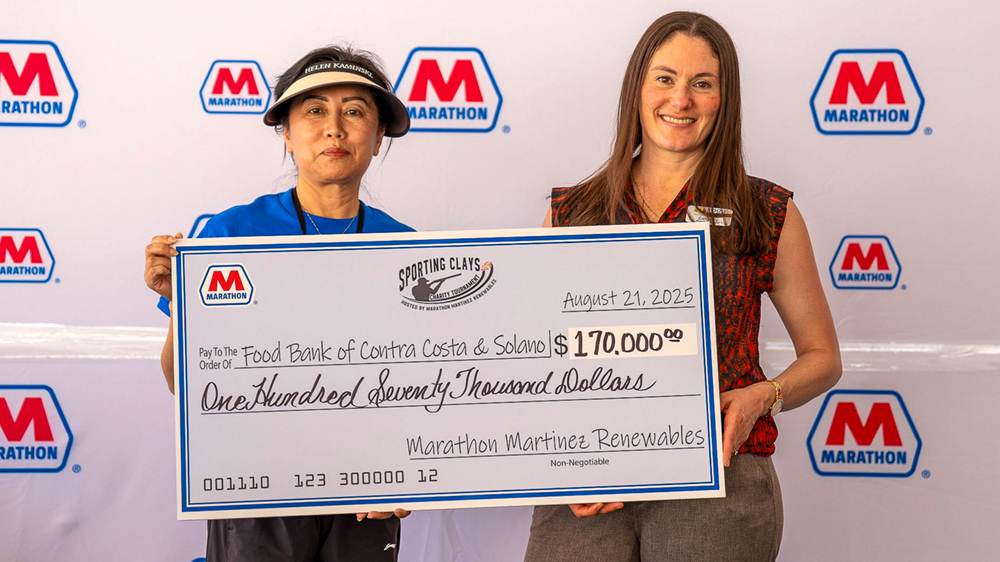 Two people holding a large check for $170,000 to the Food Bank.