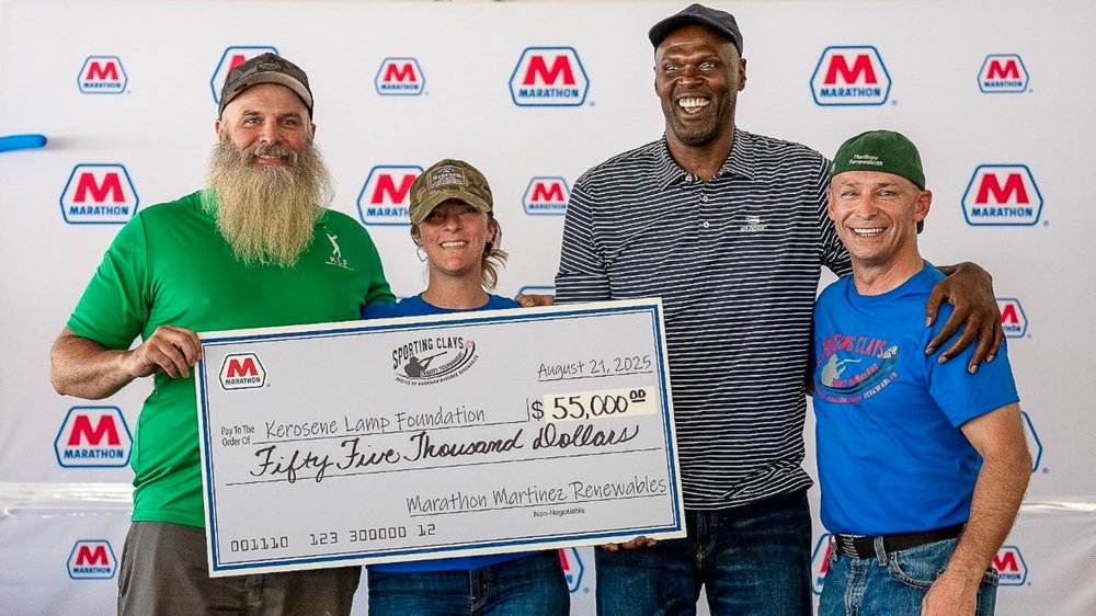 Four people holding a large check for $55,000 to the Kerosene Lamp Foundation. Four people holding a large check for $55,000 to the Kerosene Lamp Foundation.