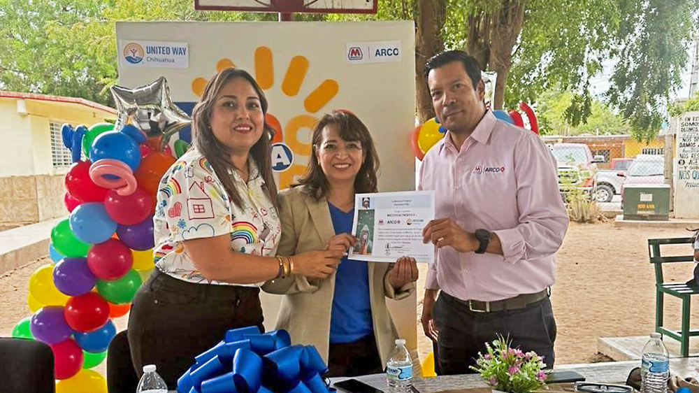 Three people stand together, holding a certificate.