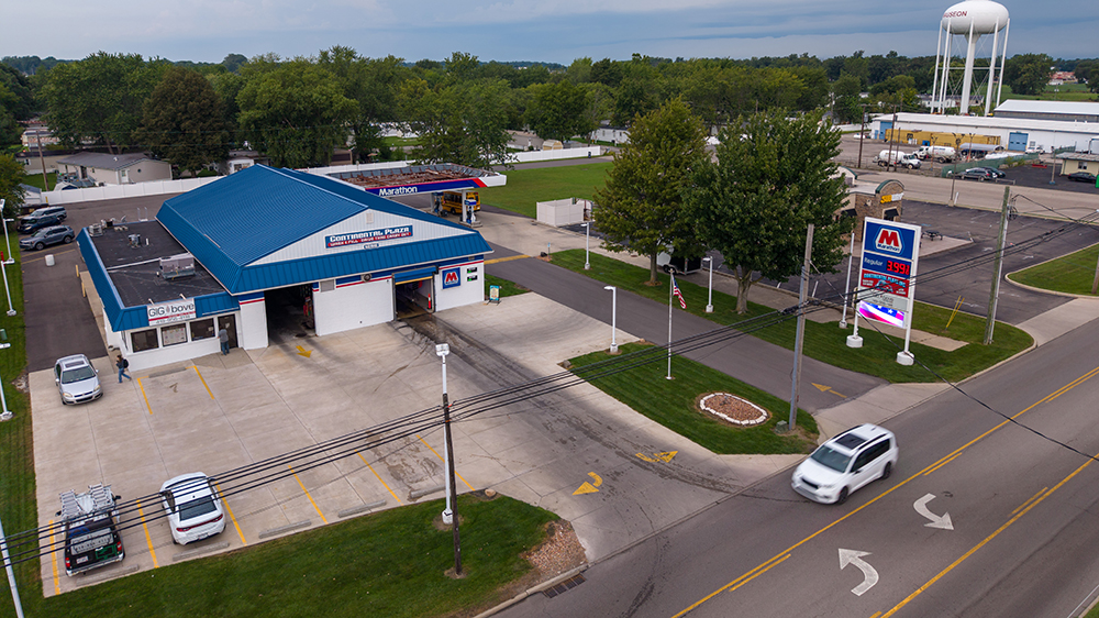 An aerial view of a gas station with a water tower in the background.