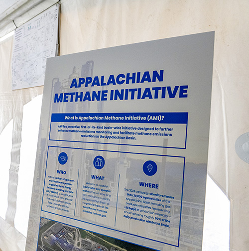 An easel board with information and images related to an ongoing emissions reduction initiative.