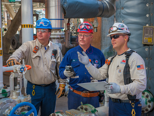 Marathon employees reading notes from a notebook